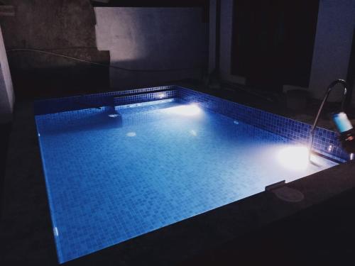 Una piscina con luces en una habitación oscura. en City Beach Apartment, en Bentota