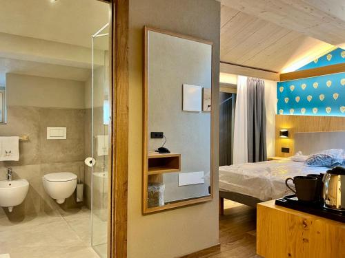 a bathroom with a bed and a toilet and a sink at Hotel Galli's - Centro in Livigno
