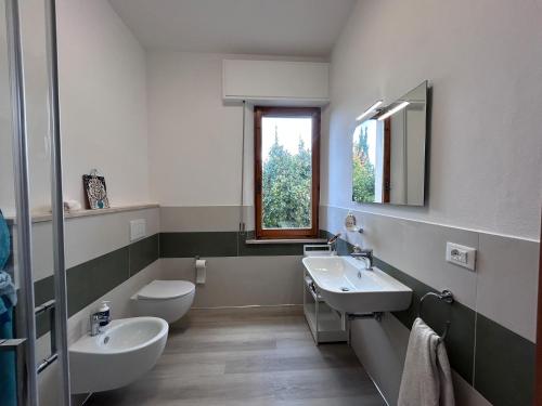 a bathroom with two sinks and a toilet and a mirror at Dimore di Sant'Albino Montepulciano in Sant'Albino
