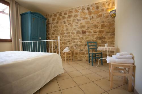 FulgatoreにあるBaglio Nuovo Country Villageのベッドルーム1室(ベッド1台、テーブル、椅子付)