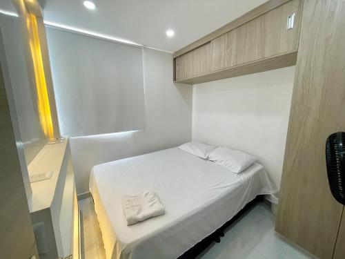 a small room with a bed and a cabinet at Loft Moderno con aire , con piscina T12 in Neiva