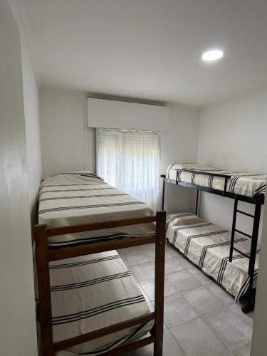 Dos literas en una habitación con ventana. en Cabaña del monte 1, en Monte Hermoso