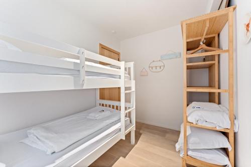 a room with two bunk beds and a closet at Sparrenduin - Compact en cosy app aan golf De Haan in De Haan