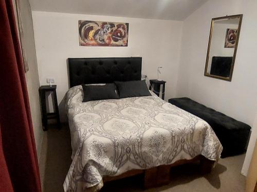 a bedroom with a large bed with a black headboard at La Loma del Valle in Tanti