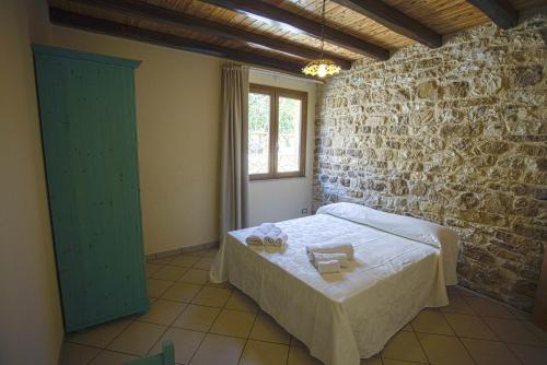 FulgatoreにあるBaglio Nuovo Country Villageの石壁のベッドルーム1室(ベッド1台付)