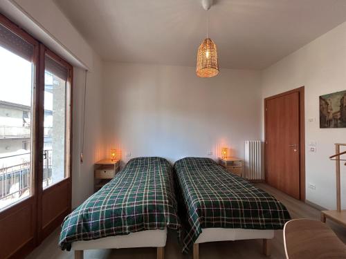a bedroom with a bed with a green plaid blanket at Dimore di Sant'Albino Montepulciano in Sant'Albino