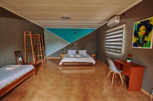 a bedroom with two beds and a desk and a bed sidx sidx sidx at Villa SAIDIA climatisée avec PISCINE in Diego Suarez
