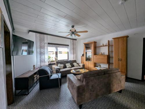 un salon avec un canapé et un ventilateur de plafond dans l'établissement Ferienwohnung Landkajüte, à Twist
