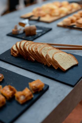Una mesa cubierta con platos negros con pan y pasteles. en Naindo Park Hotel, en La Rioja