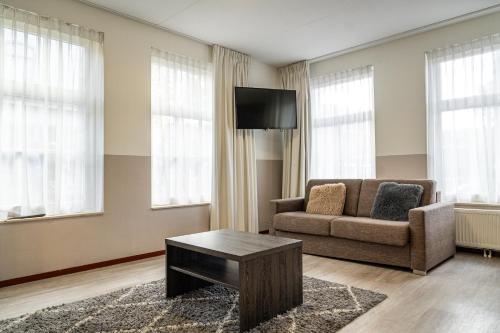 ウェースプにあるヘット ハート ファン ウェースプのソファとテレビのあるリビングルーム