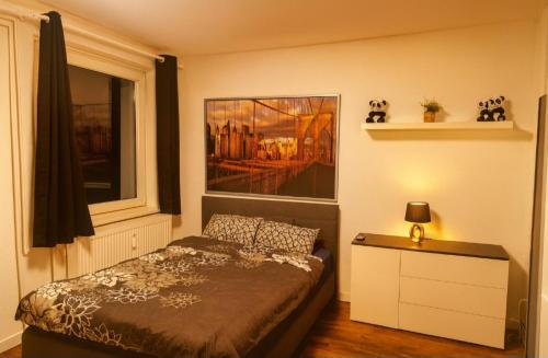 a bedroom with a bed and a painting on the wall at CityNest Hannover O5 in Hannover