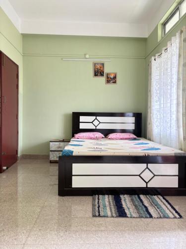 a bedroom with a bed with pink pillows on it at Aalohee Homestay in Guwahati