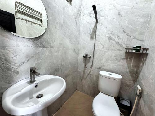 une salle de bain avec un lavabo, des toilettes et un miroir dans l'établissement GreatiStay Living&Working Canggu, à Tumbak Bayuh