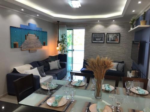 un salon avec une table et un canapé dans l'établissement Lindo apartamento em condomínio com clube, à Cabo Frio