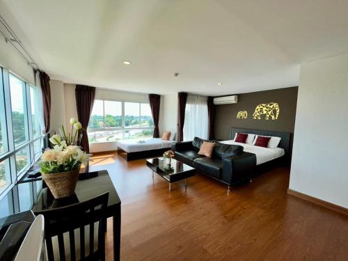 a living room with a couch and a table at Golden Good View Hotel, Chiang Mai in Chiang Mai