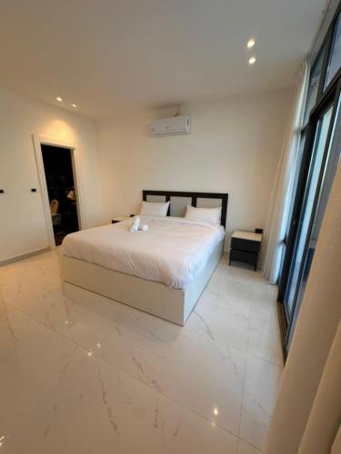a bedroom with a white bed with a marble floor at las vegas villa in Ath Thughrah