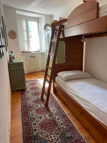 1 dormitorio con litera y alfombra en Casa Giò by Go New Location, en Terzolas