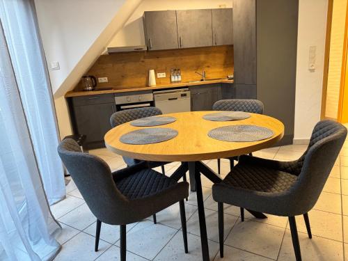 eine Küche mit einem Tisch und Stühlen in einer Küche in der Unterkunft Ferienwohnung Aischgrund in Lonnerstadt