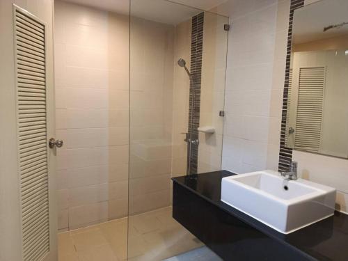 a bathroom with a sink and a glass shower at Golden Good View Hotel, Chiang Mai in Chiang Mai