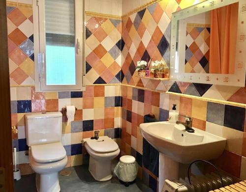 a bathroom with a toilet and a sink at La Casita de Colmenar in Villaconejos