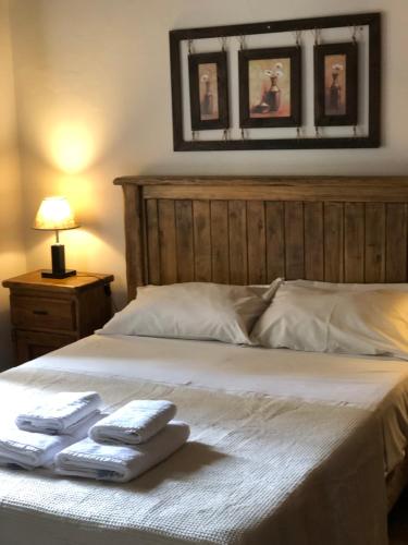a bedroom with a bed with two towels on it at La Osadia Cabañas y Suites Solo Adultos in Mina Clavero