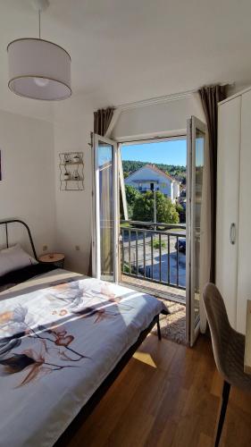 a bedroom with a bed and a balcony with a view at Mirko's home 2 Studio Apartment in Podgorica