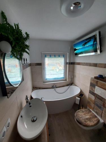 a bathroom with a bath tub and a sink at Fewo Erdgeschoss Ankerplatz mit Sauna direkt am Brombachsee bei Juliane und Klaus in Ramsberg