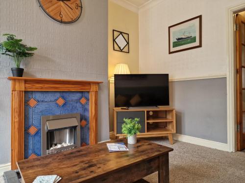a living room with a tv and a fireplace at Devon St - Cozy home, Free easy parking! in Hull