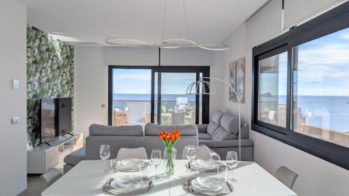 ein Wohnzimmer mit einem Tisch und einem Sofa in der Unterkunft SUNSET CLIFFS azure apartment in Benidorm