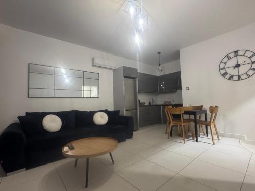 a living room with a black couch and a table at Apartament Noniewicza 95 in Suwałki