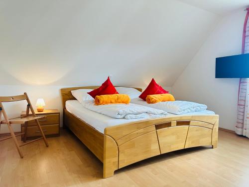 a bed with red and orange pillows in a room at Haus Abendsonne in Sankt Peter-Ording