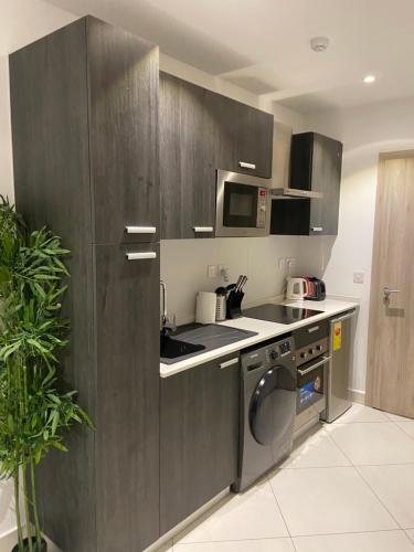 a kitchen with a sink and a washing machine at The Lennox at Airport City, Accra in Accra
