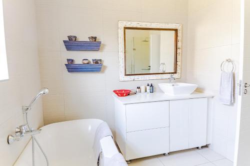 ein Badezimmer mit Badewanne, Waschbecken und Spiegel in der Unterkunft Fourways Home, Away From Home in Chartwell