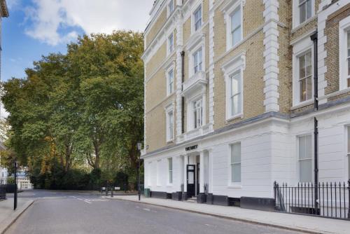 an empty street in front of a white building at The Drey - Kensington, Earl's Court in London