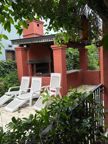 a group of white chairs in front of a fireplace at Casa divina in Yerba Buena