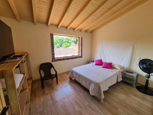 a bedroom with a bed with pink pillows and a window at Apartamento El trigal in Barichara