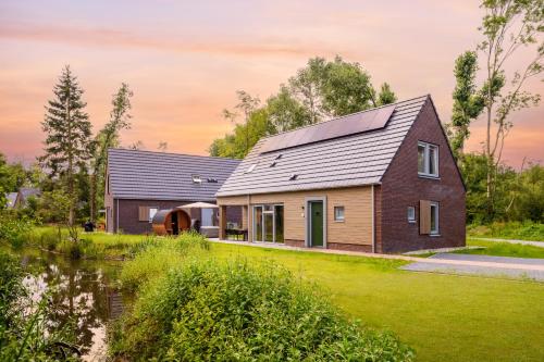 a house with a metal roof and a yard at Dormio Resort De Hondsrug in Gasselte