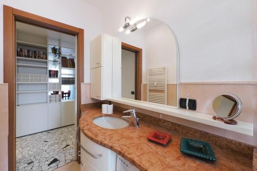 een badkamer met een wastafel en een spiegel bij Primopiano - Corsica in Milaan