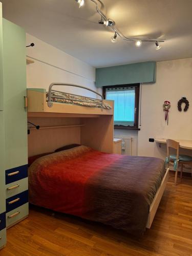 a bedroom with a bunk bed and a desk at Mountain house Pieve di Cadore in Pieve di Cadore