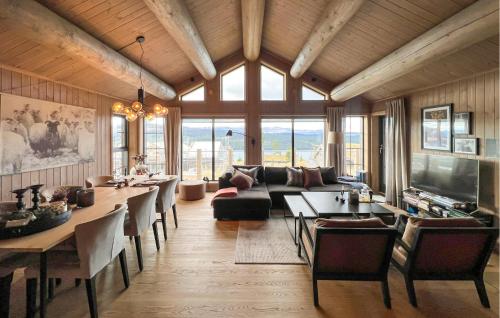a living room with a couch and a table with chairs at Amazing Home In Gålå With Sauna in Gålå