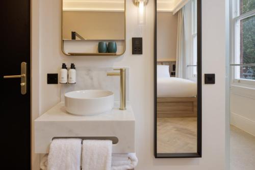 a bathroom with a sink and a mirror at The Drey - Kensington, Earl's Court in London