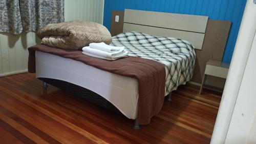 a small bed in a room with a wooden floor at Chalé Paraíso Da Serra 01 in Gramado