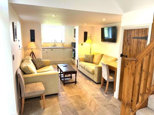 ein Wohnzimmer mit Sofa und Tisch in der Unterkunft The Stables, a delightful 3 bed house near the Norfolk Broads in Upton