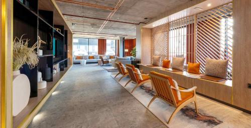 a row of chairs in a room with windows at Sandman Signature Glasgow Hotel in Glasgow