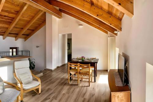 a dining room and living room with a table and chairs at La Mansarda Di Crevari in Crevari