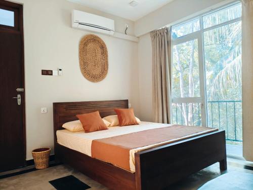 a bedroom with a bed and a large window at Lagoonai Villa in Sinimodera