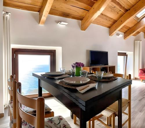a dining room with a black table and chairs at La Mansarda Di Crevari in Crevari