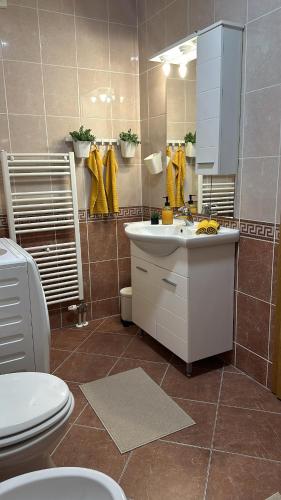 a bathroom with a sink and a toilet and a mirror at Apartman Centar in Valpovo
