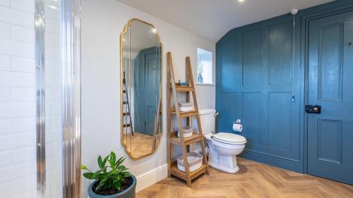 a bathroom with a toilet and a mirror at Church House in Beaumaris
