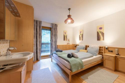 a bedroom with a bed and a sink and a tub at Residenz Maroi - Wasle in Sankt Anton am Arlberg